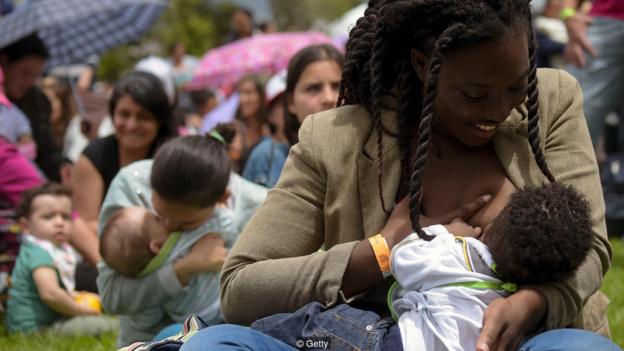 一名哥伦比亚女子正在“世界母乳喂养节”上喂养自己的孩子。母乳的保护性功效一直被视为母乳喂养的益处之一。